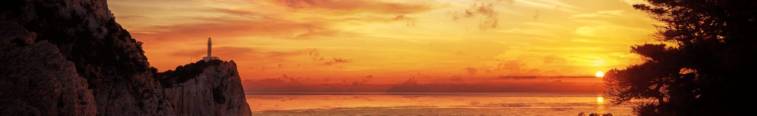 Solnedgång över havet med fyrtorn och klippor